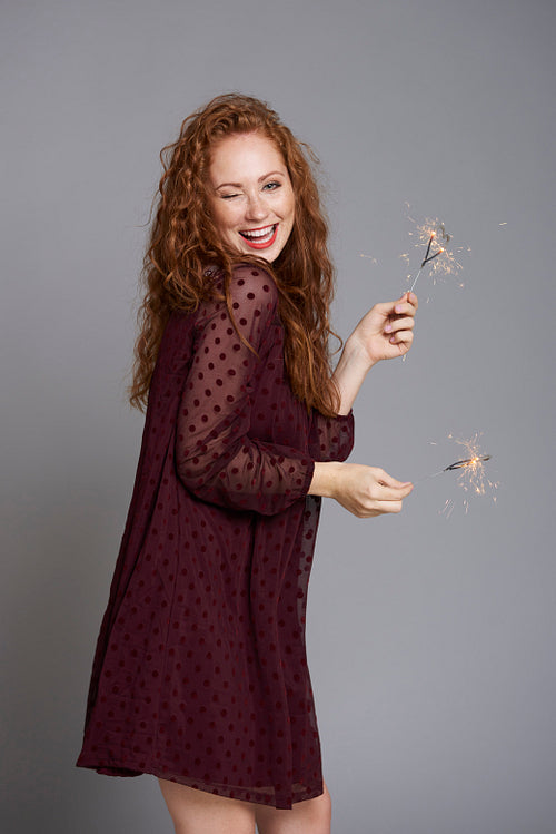 Portrait of happy woman with burning sparklers