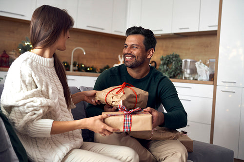 Multi ethnicity couple sharing Christmas present together at home
