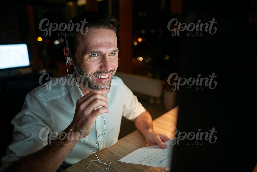 Man listening to music and working late in his office