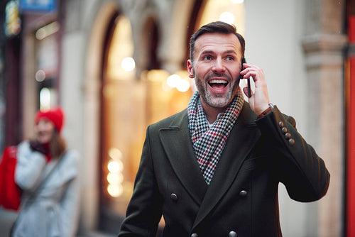 Excited mature man is on the phone