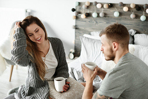 Couple drinking morning coffee at bedroom