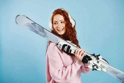 Smiling girl holding her skis