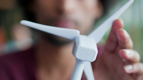 Close up of African man holding model of wind turbine