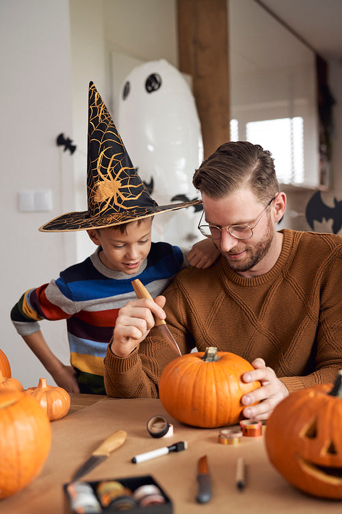 Father with son carving a pumpkin