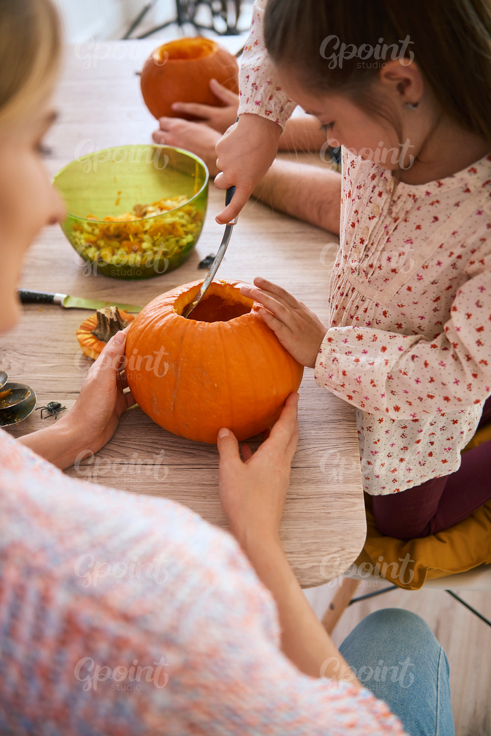 Side view of girl carving pumpkin for Halloween