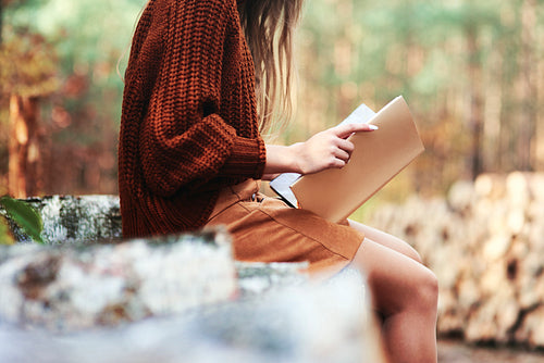Woman in autumnal forest reading a book
