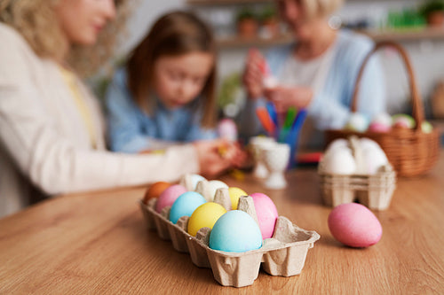 Close up of carton of colored Easter eggs in the table