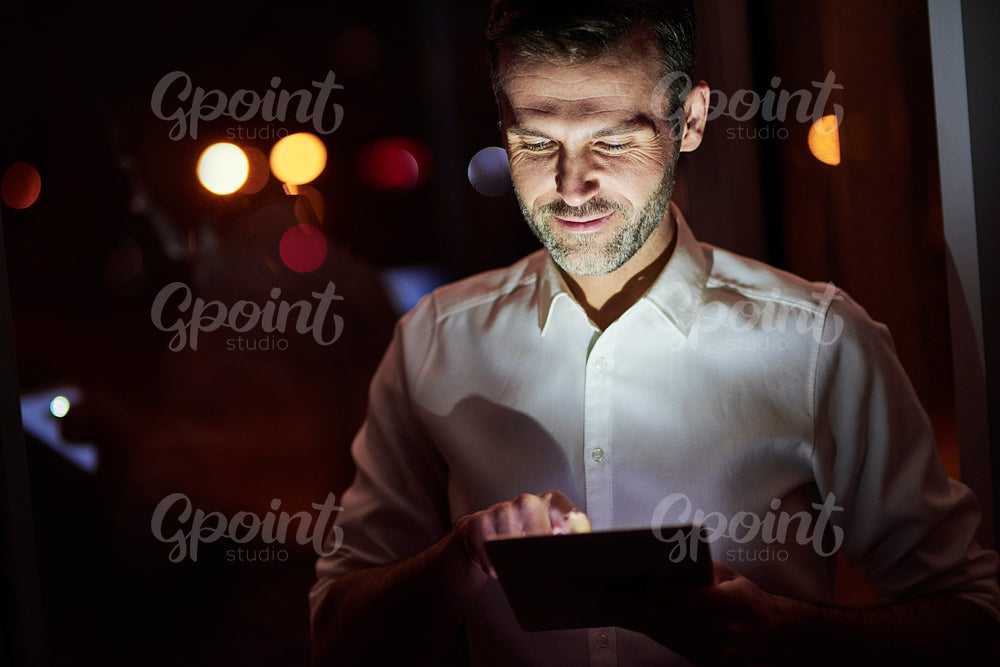 Mature men using a tablet at night
