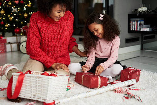 African woman and her daughter packing Christmas presents