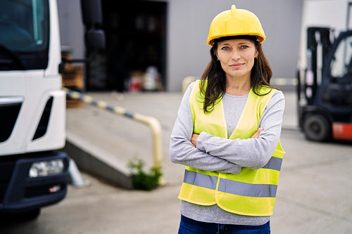 Caucasian mature woman in front of warehouse