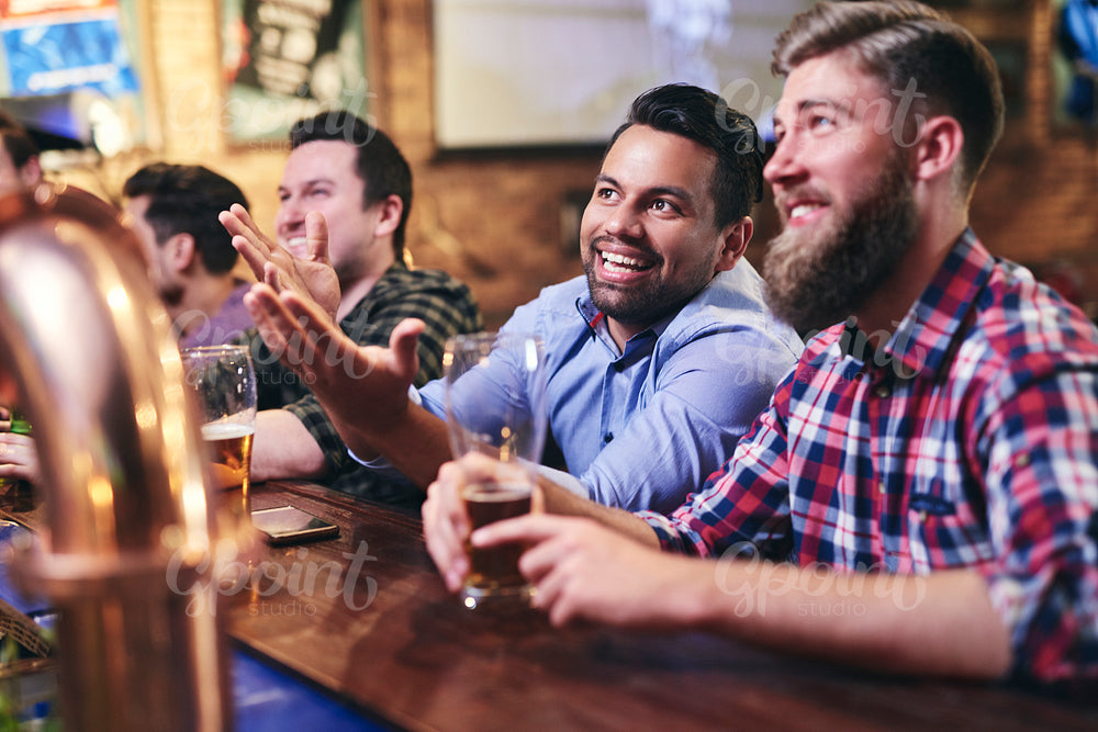 Mature men watching the football game at the bar