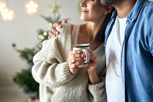 Close up of couple standing at home at Christmas time and looking away