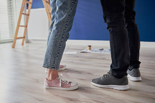 Legs of couple standing in new apartment