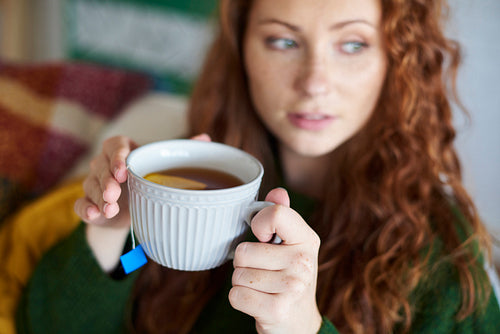 Woman's hands holding a cup of hot tea with lemon