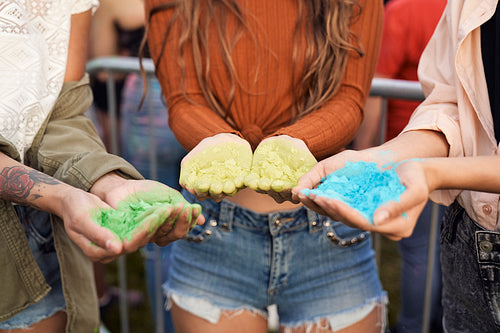 Close up of hands holding coloured powder at music festival