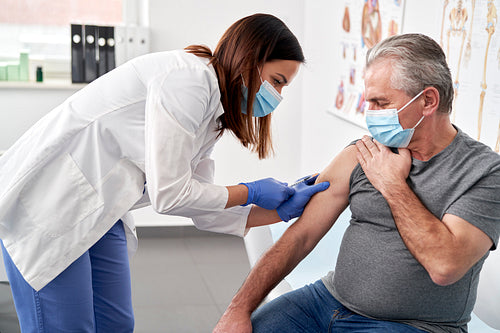 Senior man being vaccinated in a doctor's office