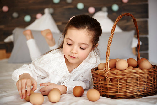 Girl having fun with eggs in bed