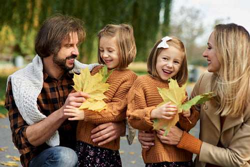 Parents and children picking leafs on the fall season