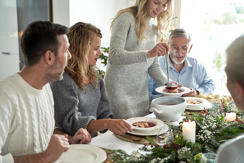 Caucasian family start eating traditional Polish soup at Christmas Eve