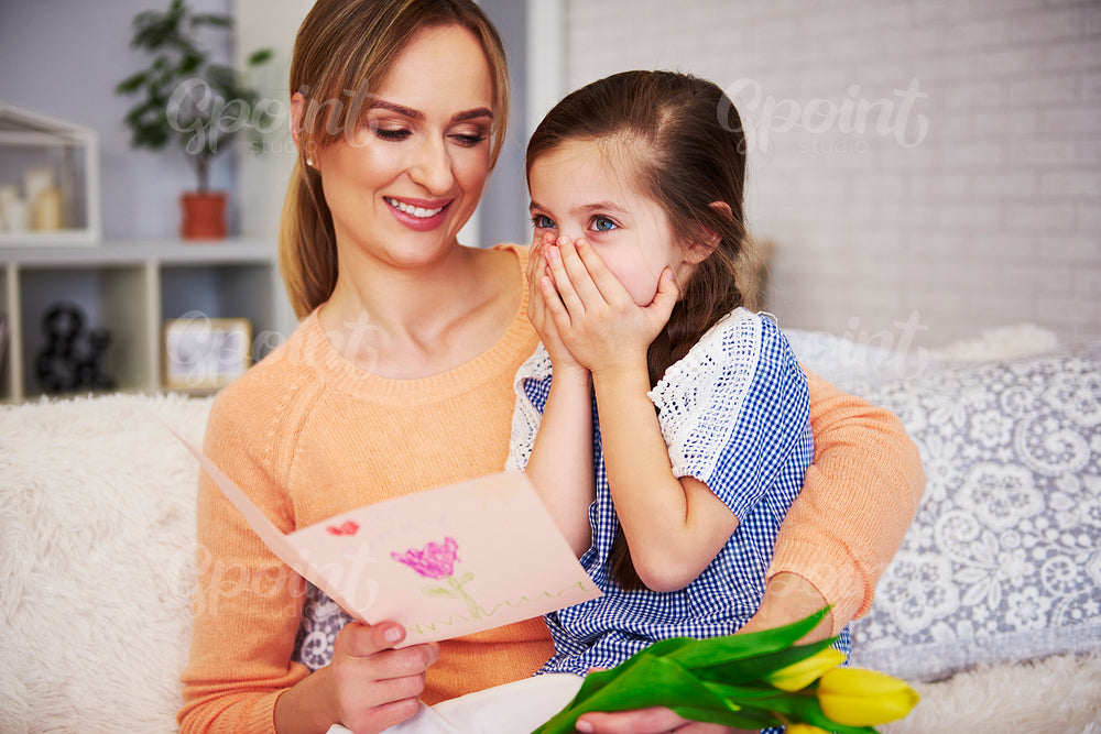 Young mom reading Mother's Day greeting card