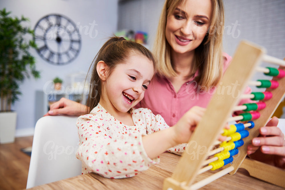 Girl and teacher using an abacus during homeschooling