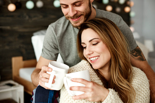 In love couple drinking coffee in bedroom