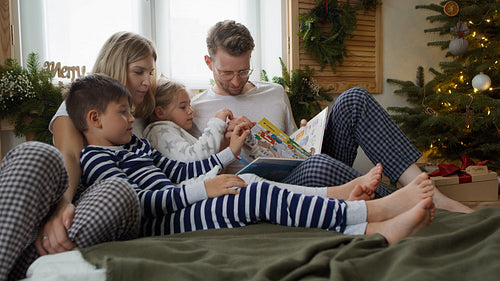 Family reading books at Christmas morning