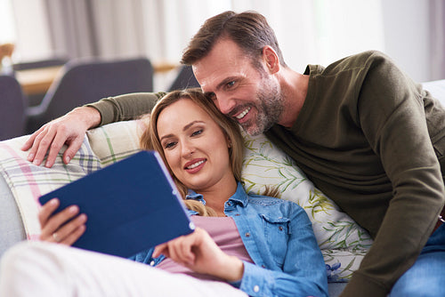 Mature couple using a tablet in living room