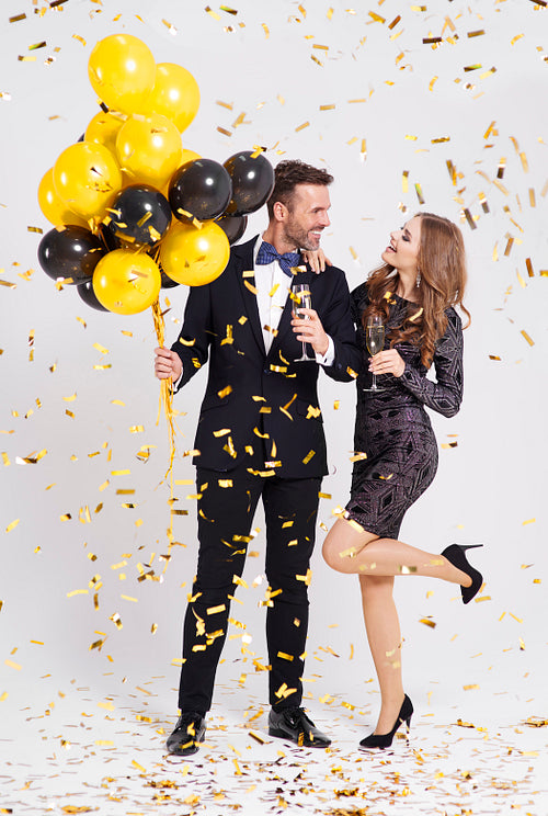 Couple with balloons and champagne flute celebrating new year