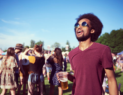 Young African man drinking beer at the festival