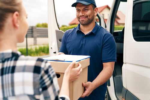 Smiling delivery person giving package to woman