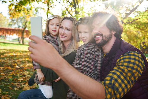 Happy family making a selfie in autumn forest