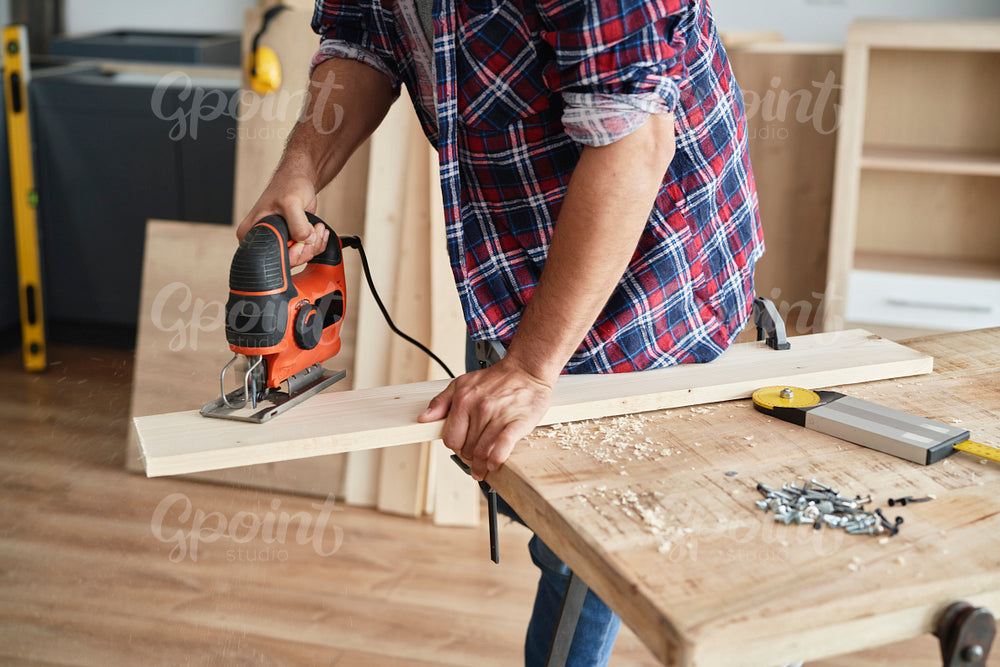 Carpenter cutting the boards to size using a jigsaw