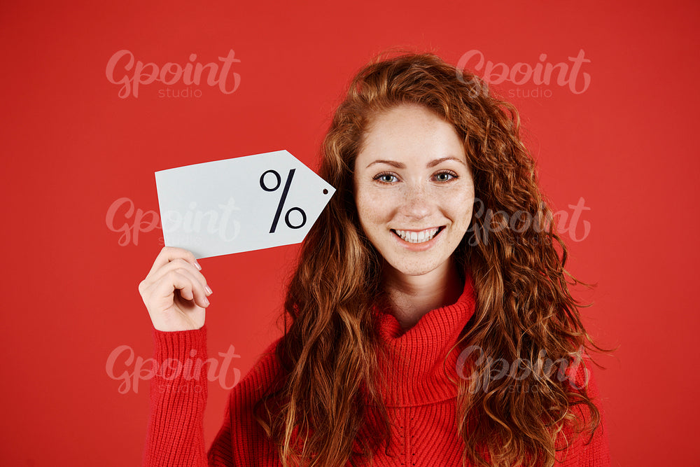 Smiling woman holding blank price tag
