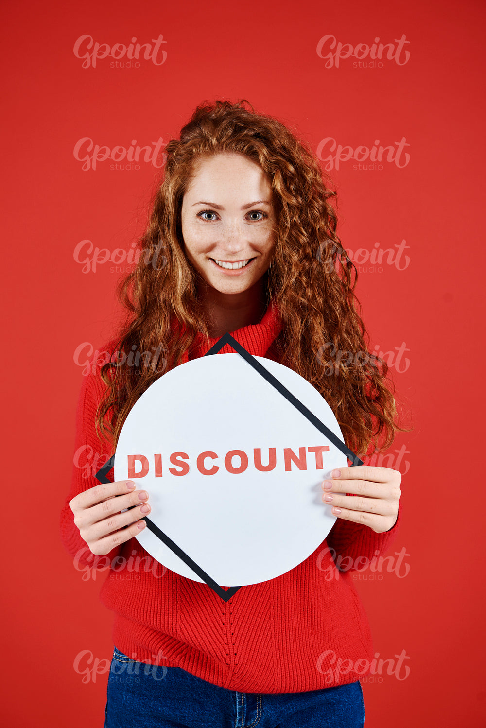 Shot of smiling woman showing banner of winter sale