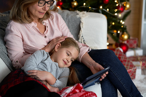 Grandmother with granddaughter watching cartoons on the tablet