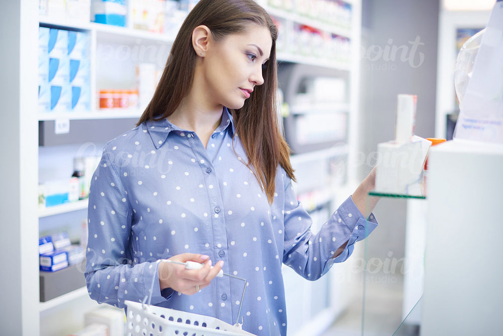 Young woman buying medicines at health shop