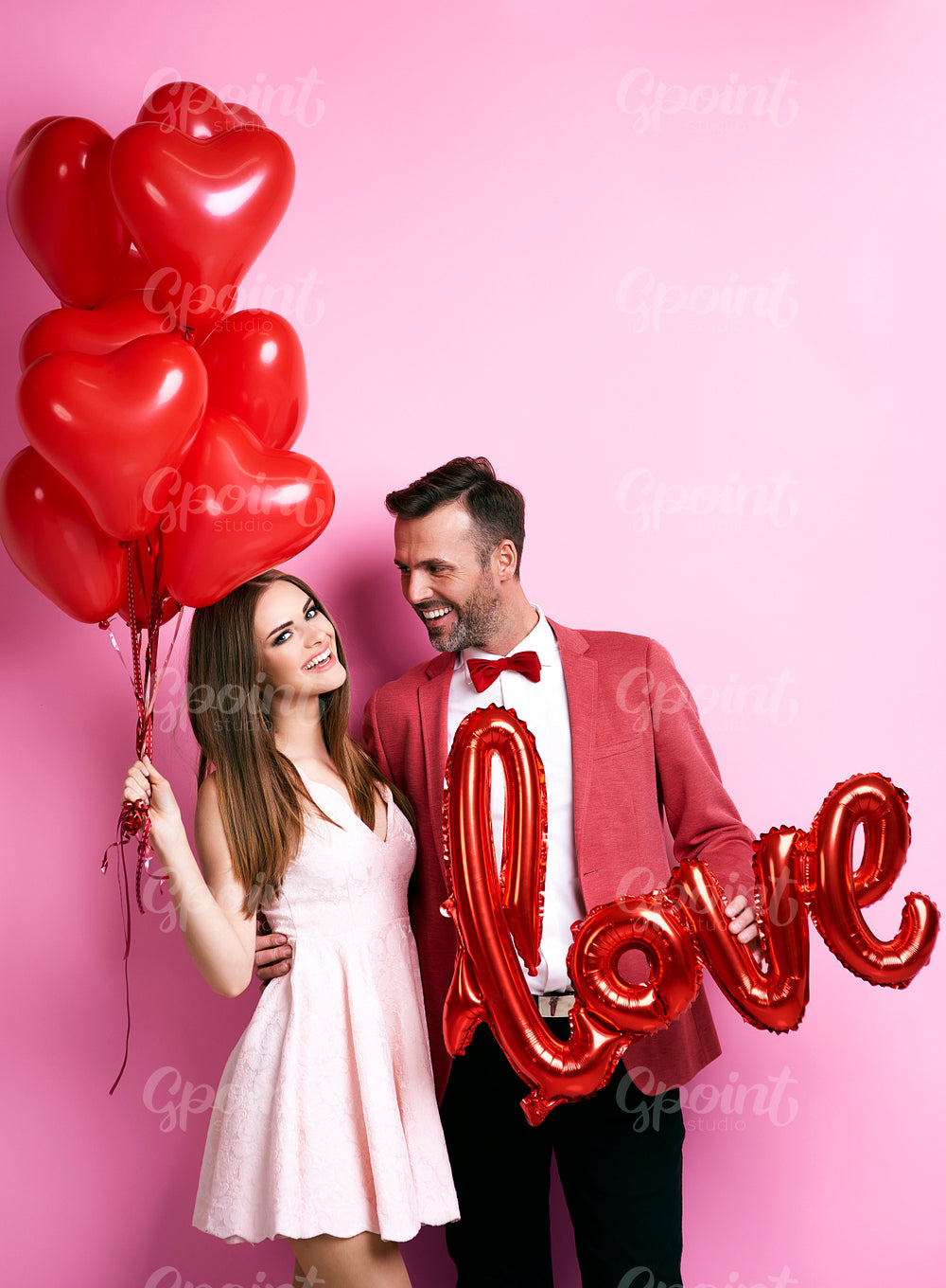 Affectionate couple with balloons embracing