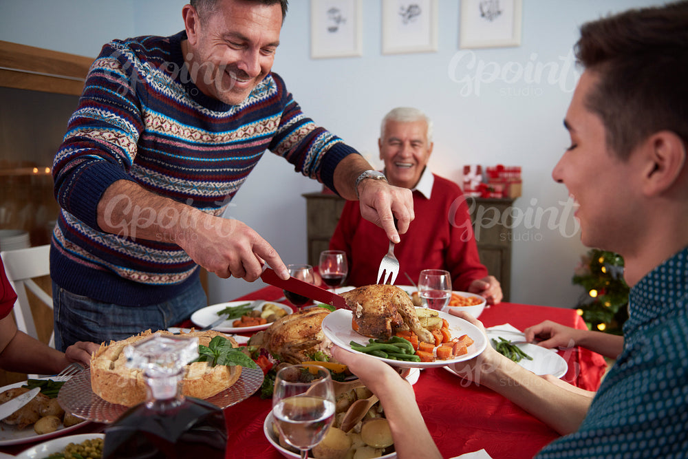 Father serves dinner at Christmas Eve