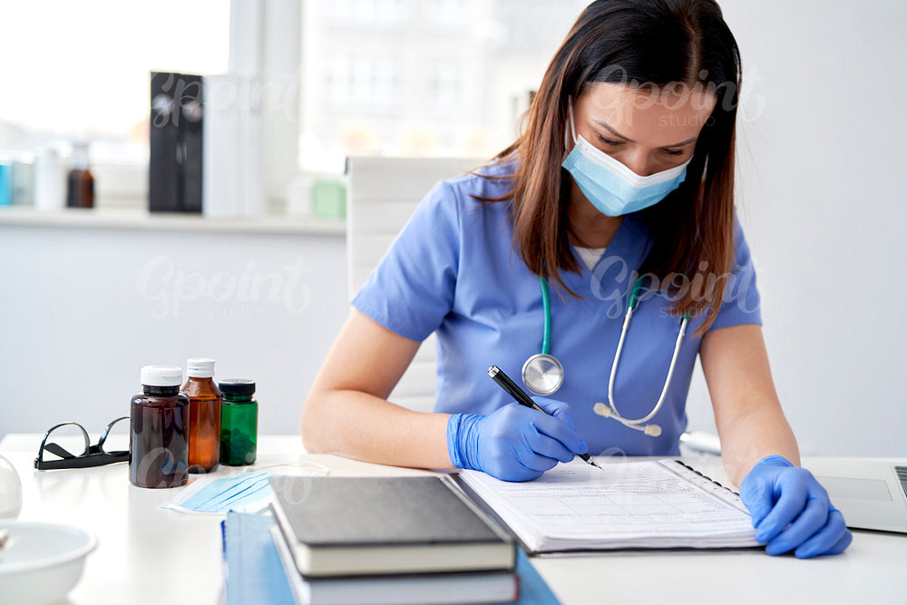 Female doctor filling out medical records
