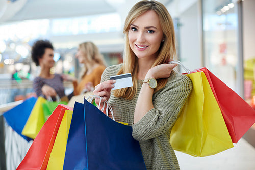 Woman with credit card and full shopping bags