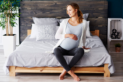 Portrait of pregnant woman resting at bedroom