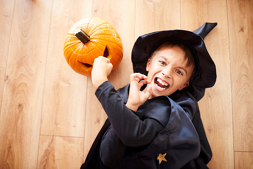 Little wizard on the floor with pumpkin