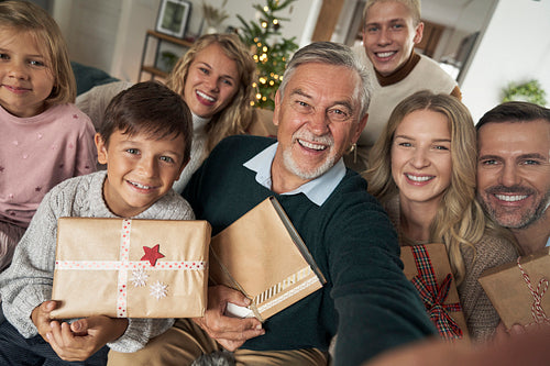 Caucasian family of different generation taking selfie with Christmas presents
