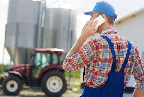 Rear view of farmer talking on the phone