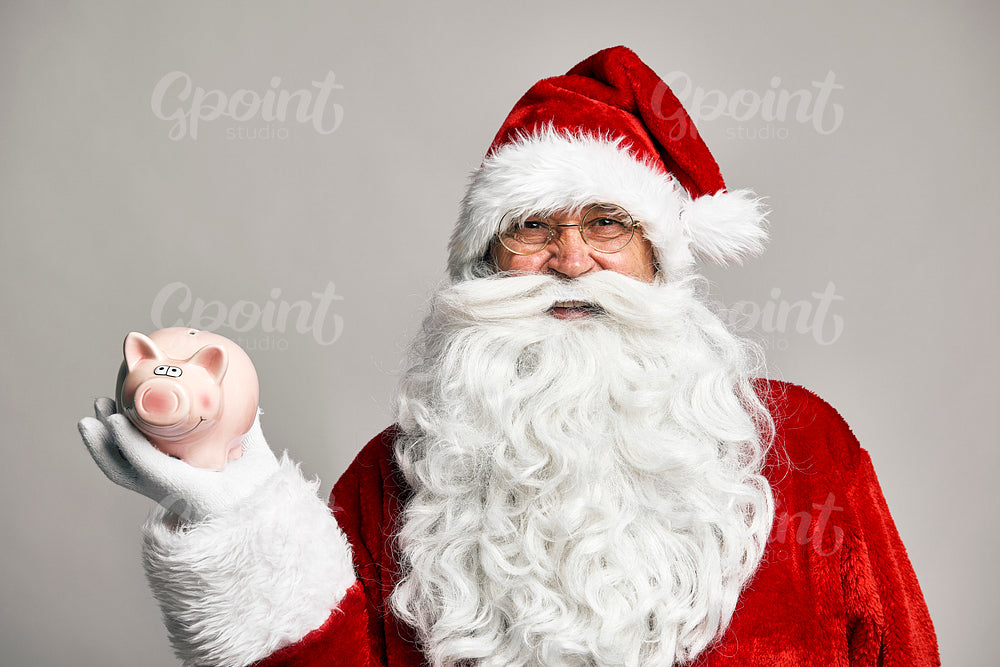 Caucasian Santa Claus holding piggy bank on the hand 