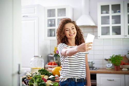 Woman taking selfie in the kitchen