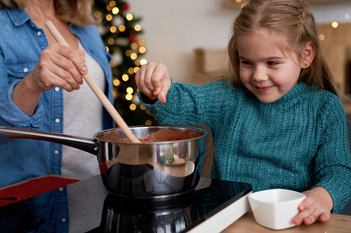 Little girl seasoning the homemade dish while Christmas cooking