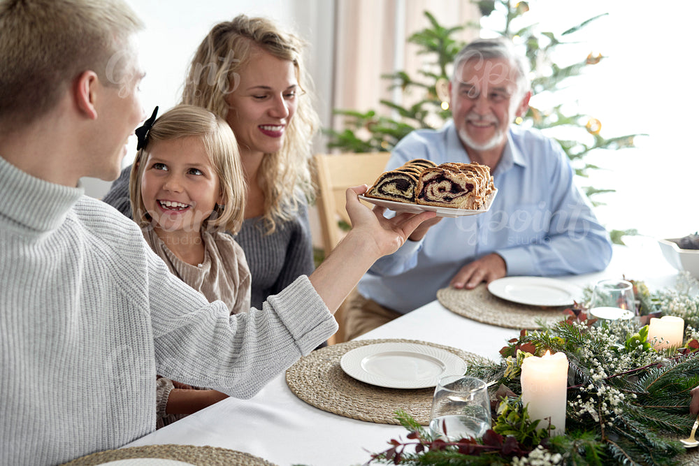 Caucasian family sharing poppy seed cake during the Christmas Eve