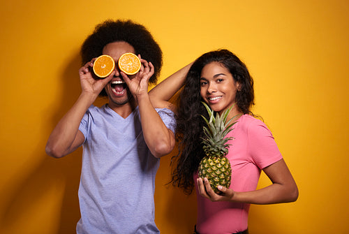 Afroamerican couple cheering with exotic fruits